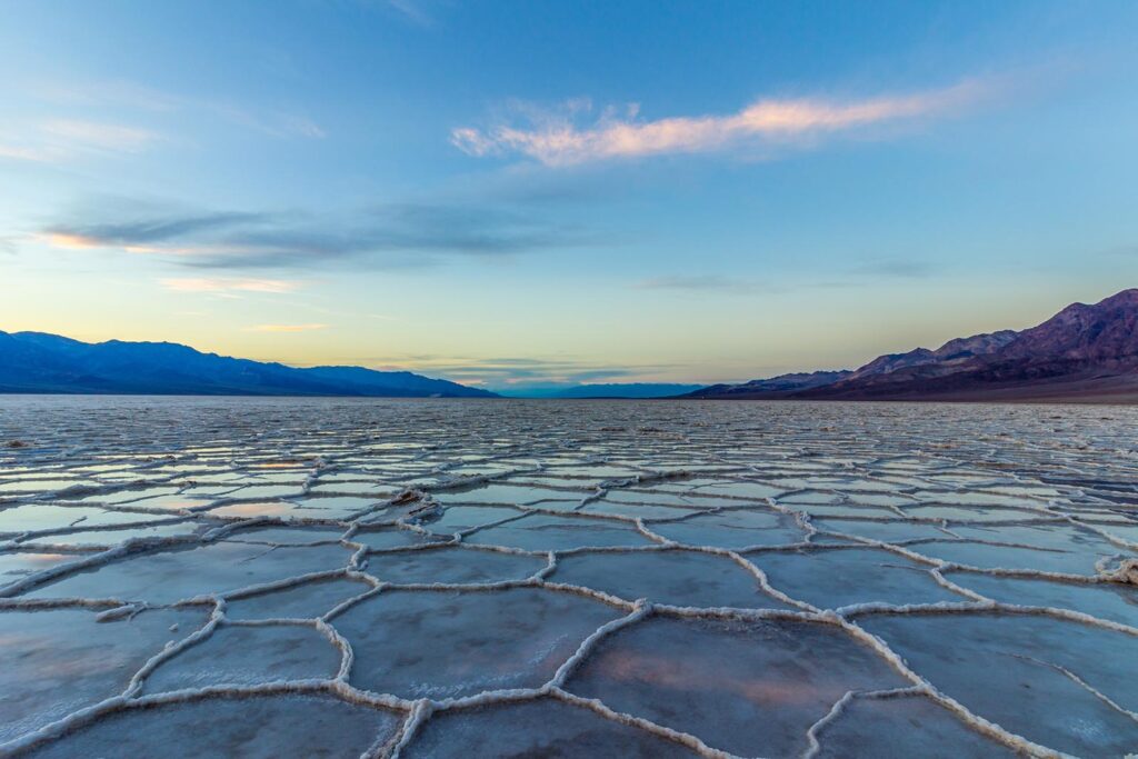 Badwater Basin at Sunset. Salt crust and clouds reflection. Death Valley National Park. California, USA