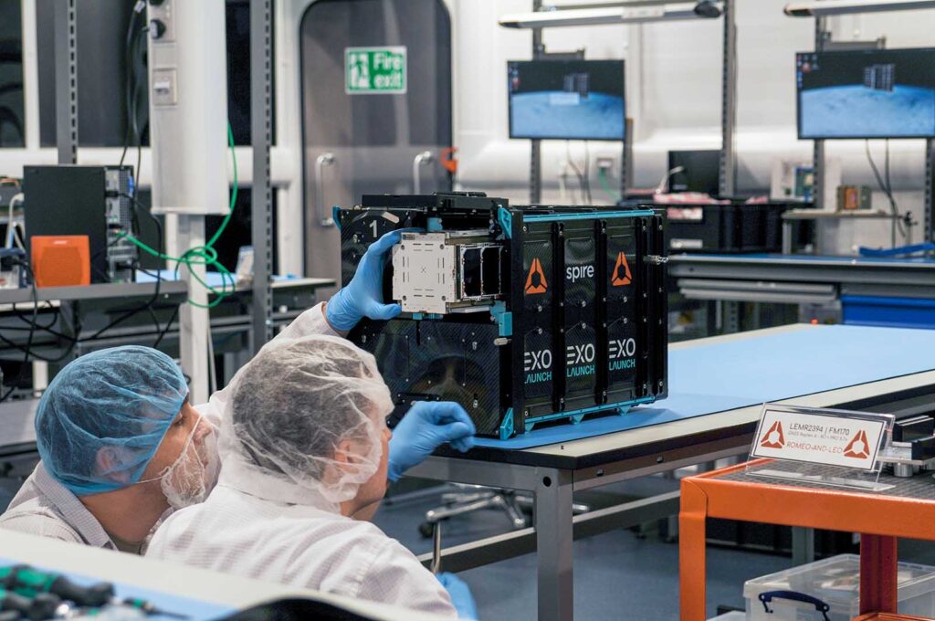 Spire engineers inserting nanosatellite into deployer